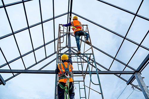 Worker wearing a safety harness while working at height on an access platform
